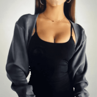 Woman in black dress and gray jacket.
